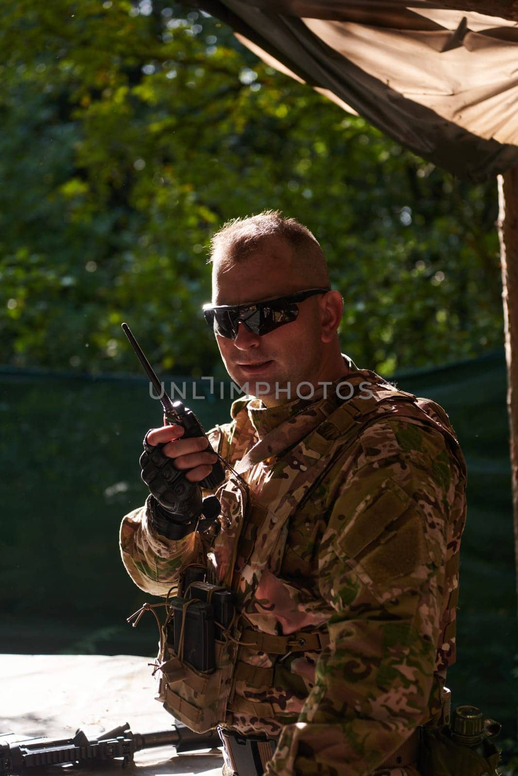 A military major employs a Motorola radio for seamless communication with his fellow soldiers during a tactical operation, showcasing professionalism and strategic coordination by dotshock