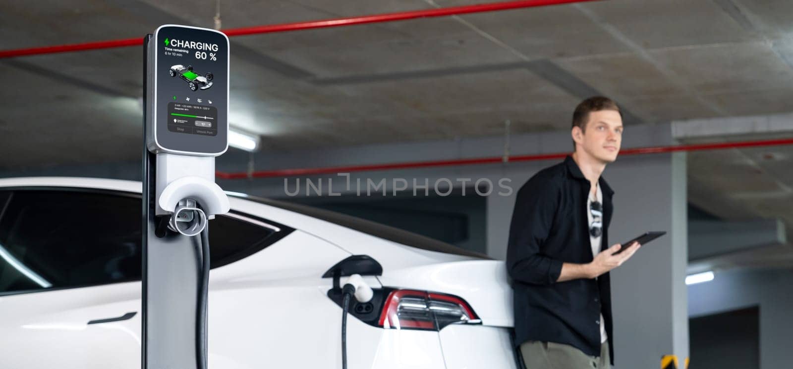 Young man travel with EV electric car to shopping center parking lot charging in downtown city showing urban sustainability lifestyle by green clean rechargeable energy of electric vehicle innards