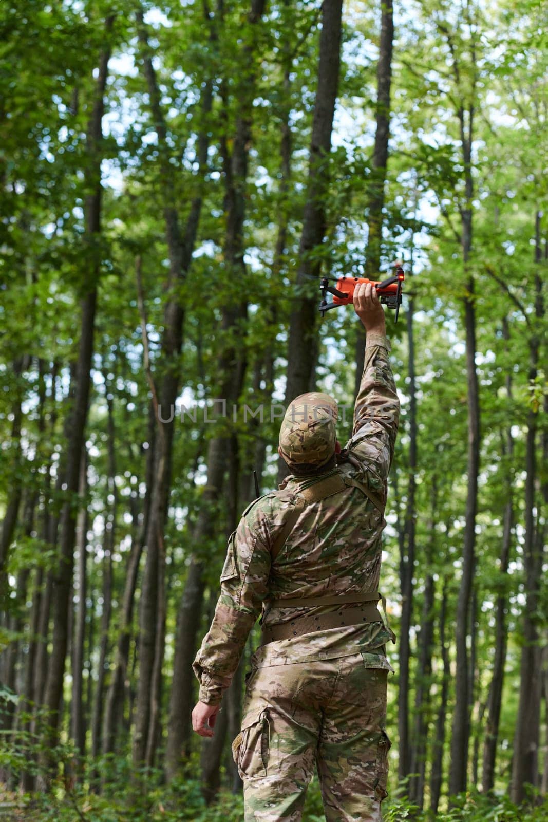 Elite military unit, equipped with state-of-the-art technology including a drone, strategically navigates and surveys dangerous wooded terrain, showcasing their precision, cooperation, and specialized training for high-risk operations by dotshock