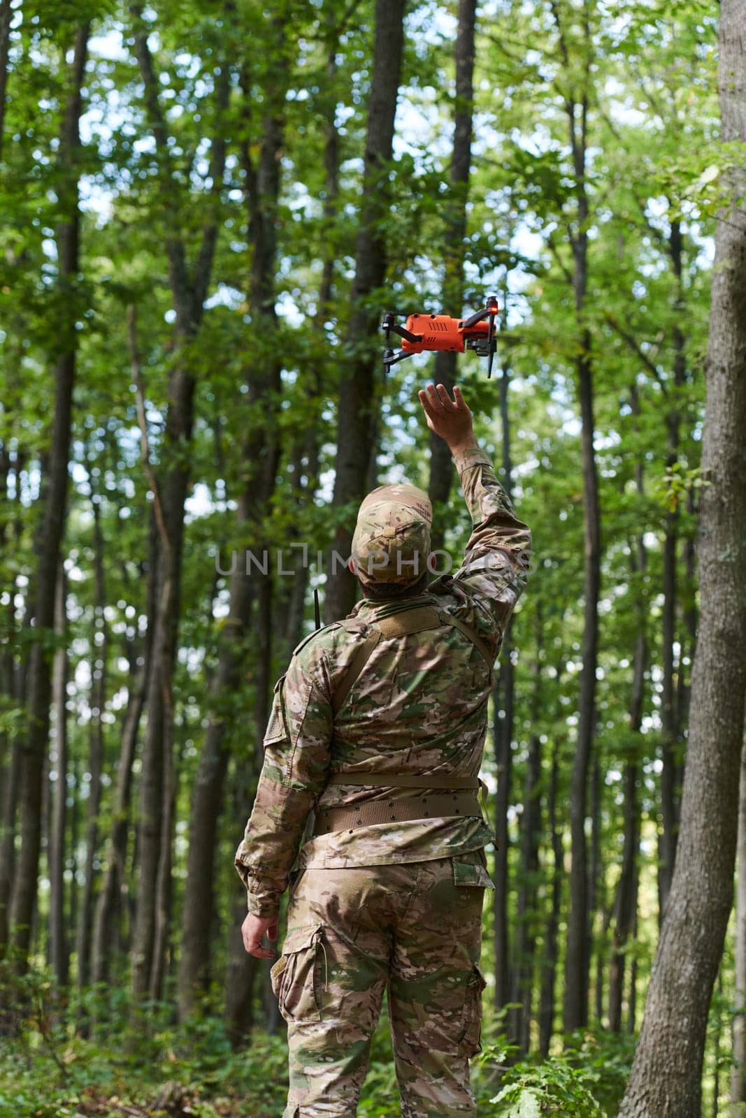 Elite military unit, equipped with state-of-the-art technology including a drone, strategically navigates and surveys dangerous wooded terrain, showcasing their precision, cooperation, and specialized training for high-risk operations by dotshock