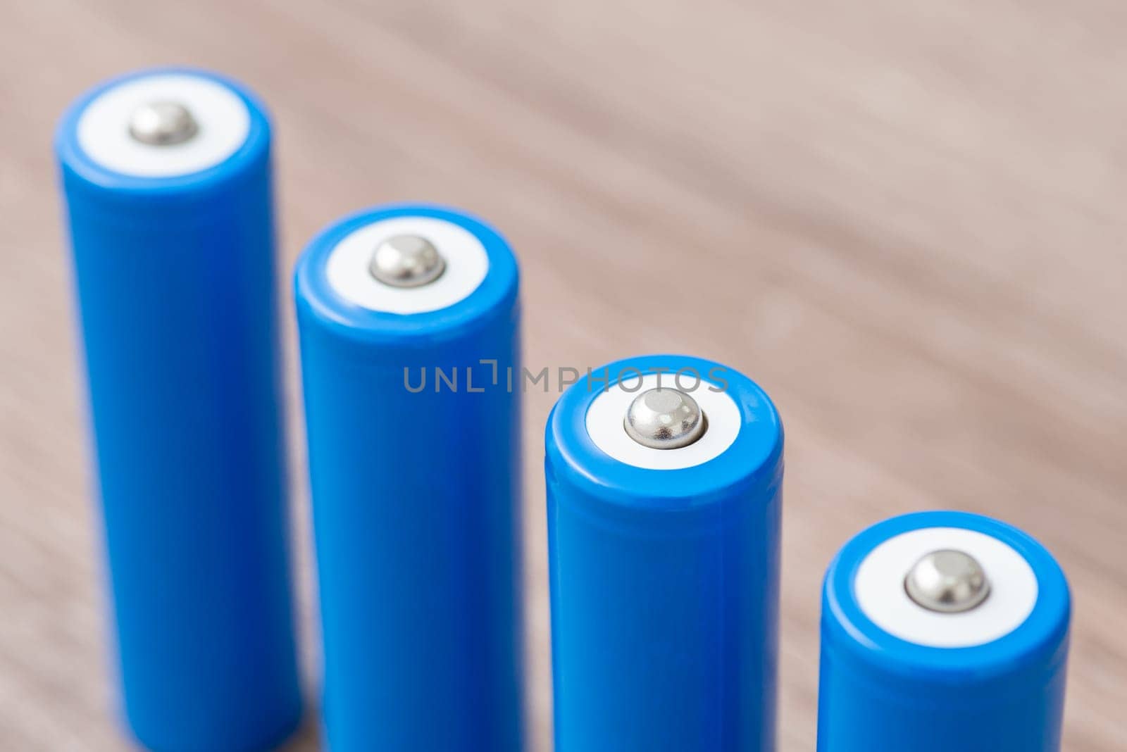 Close up of four blue 18650 batteries on the table by VitaliiPetrushenko