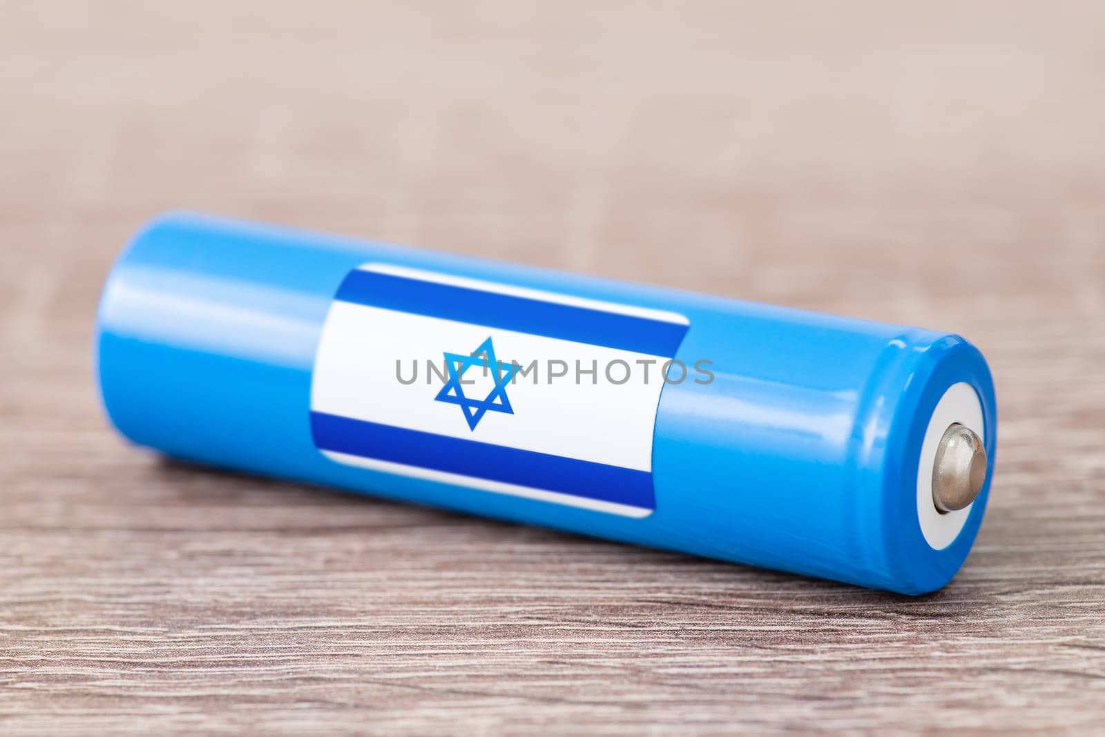 Rechargeable battery with flag of Israel on table by VitaliiPetrushenko