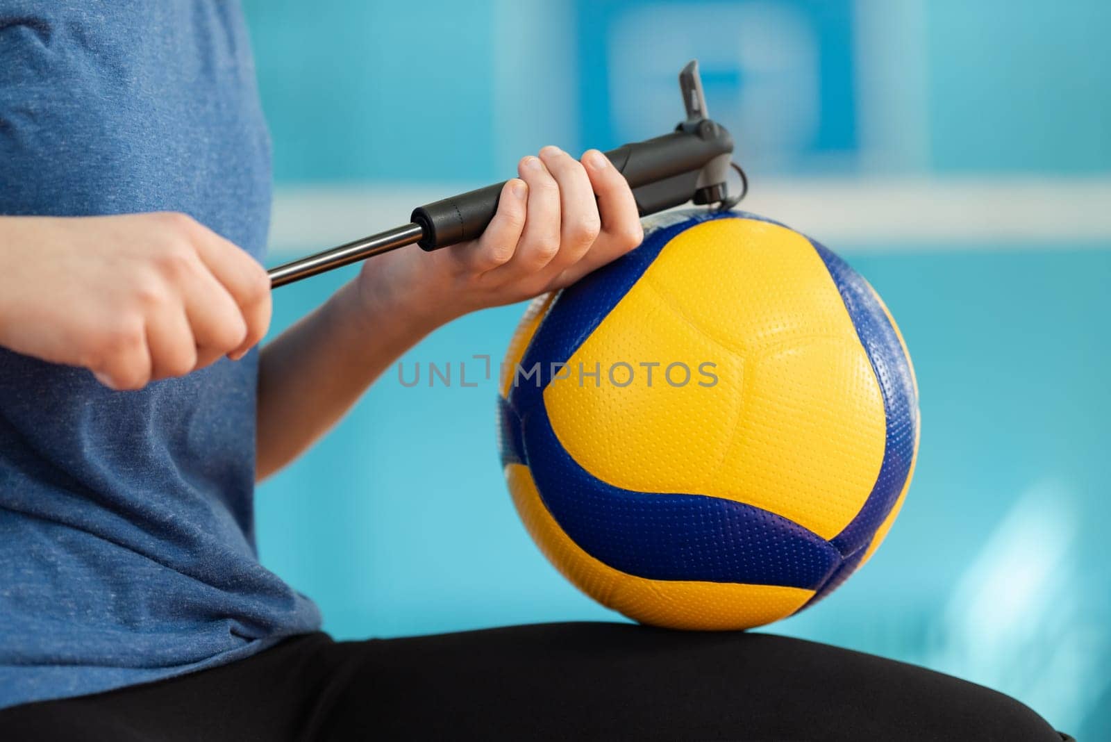 Close up of female inflating volleyball with a small velo pump by VitaliiPetrushenko