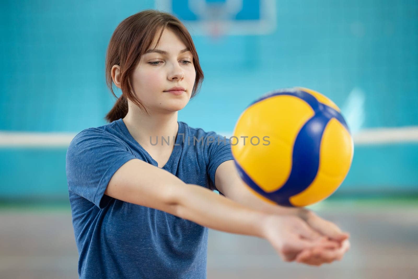 Young girl playing volleyball indoors by VitaliiPetrushenko