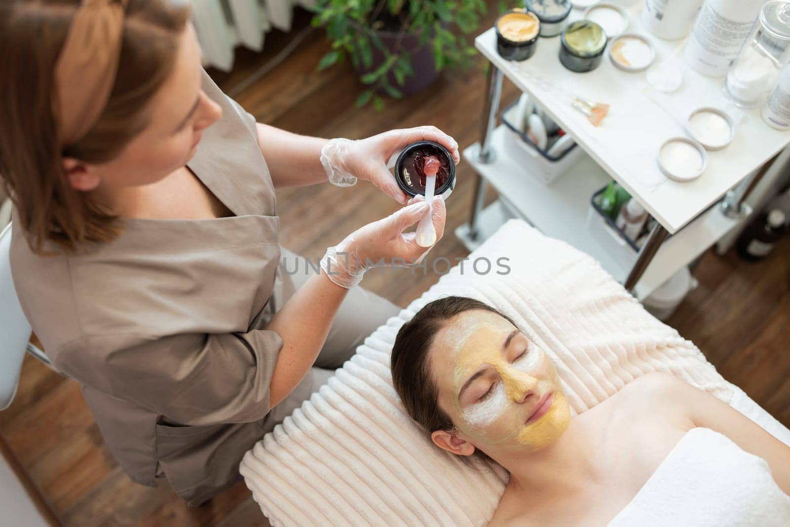 Female client of spa salon enjoys beauty procedure of her face by VitaliiPetrushenko