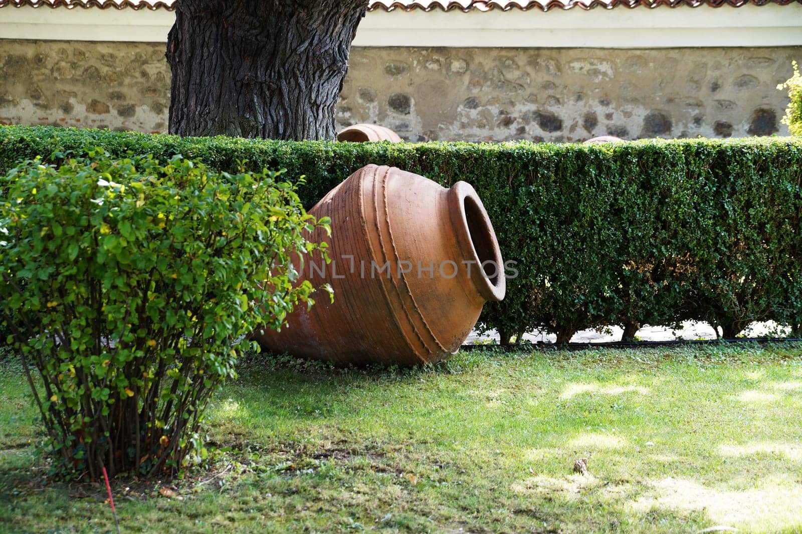 fallen clay jug as an element of landscape design in the garden.