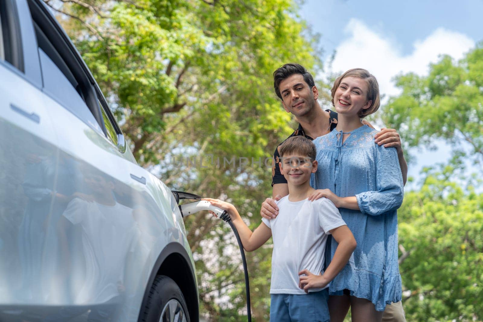 Family road trip vacation with electric vehicle, lovely family recharge EV car with green and clean energy. Natural and eco friendly car travel for sustainable environment. Perpetual