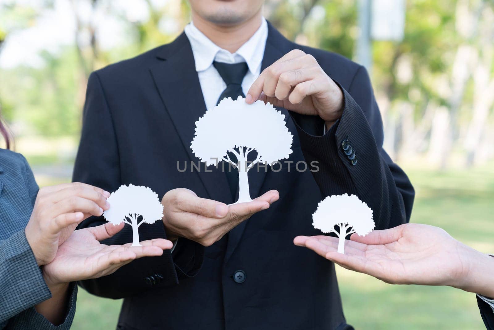 Group of business people holding white paper tree. Gyre by biancoblue