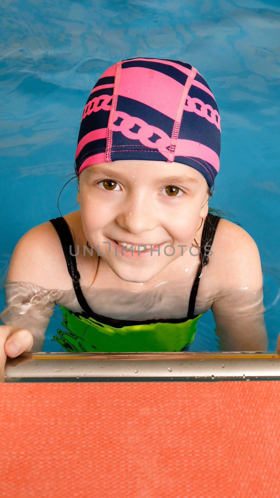 Portrait of a little girl having fun in indoor swimming pool