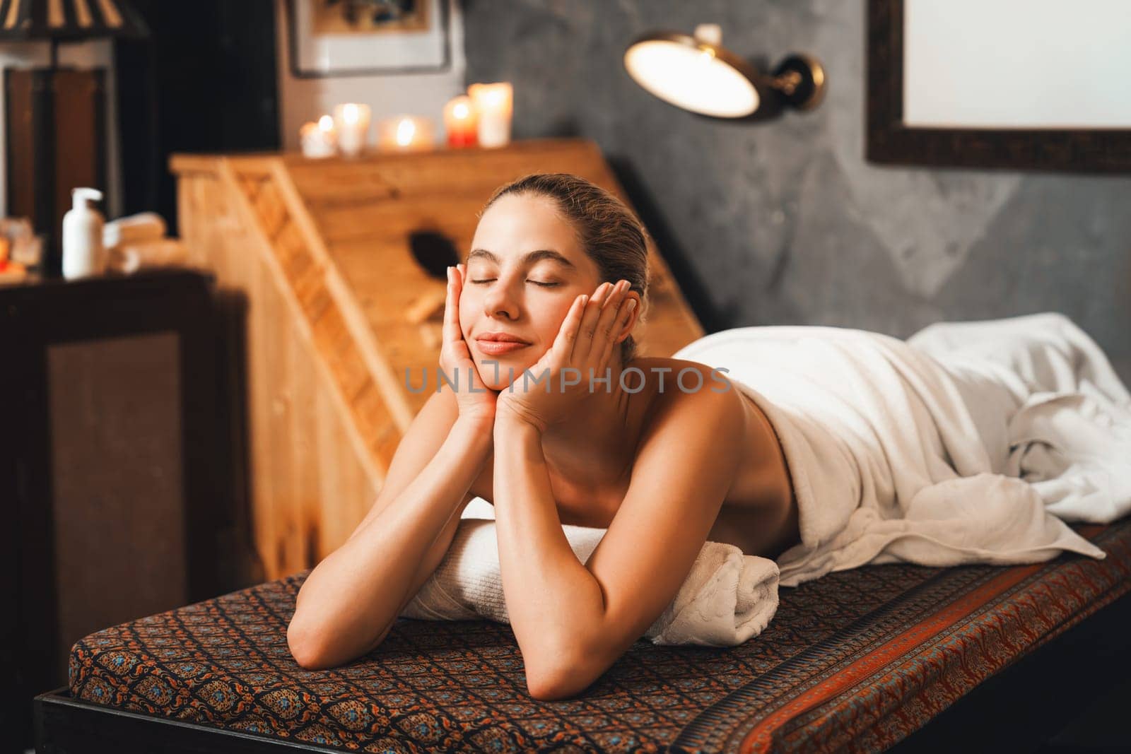 Beautiful woman lies on spa bed in front of wooden sauna cabinet. Tranquility. by biancoblue