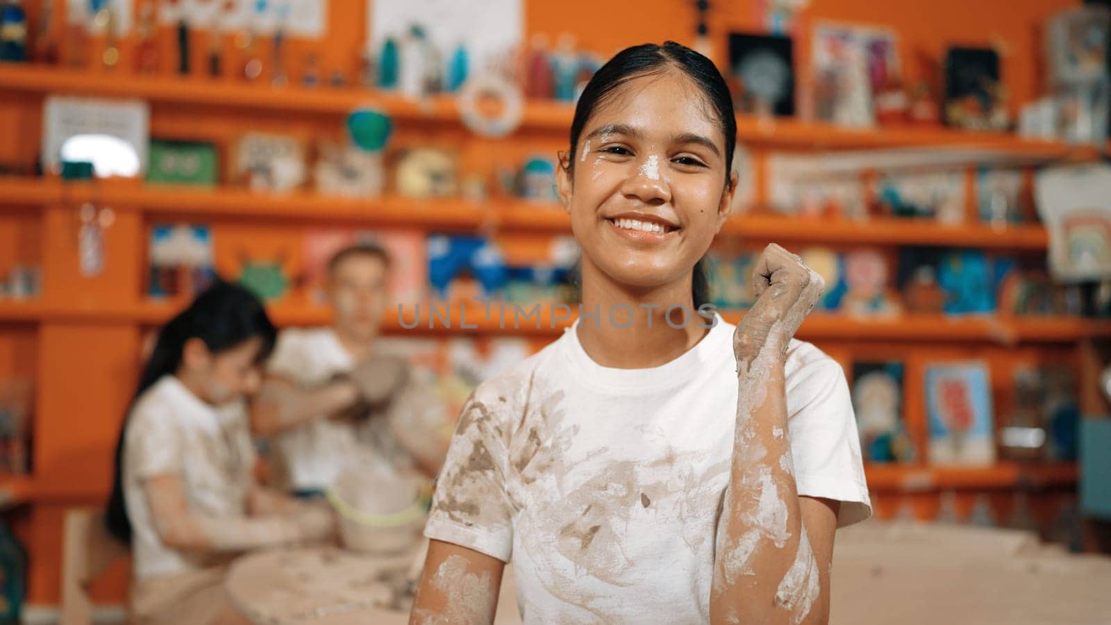 Happy caucasian girl pose at camera while children modeling clay. Edification. by biancoblue