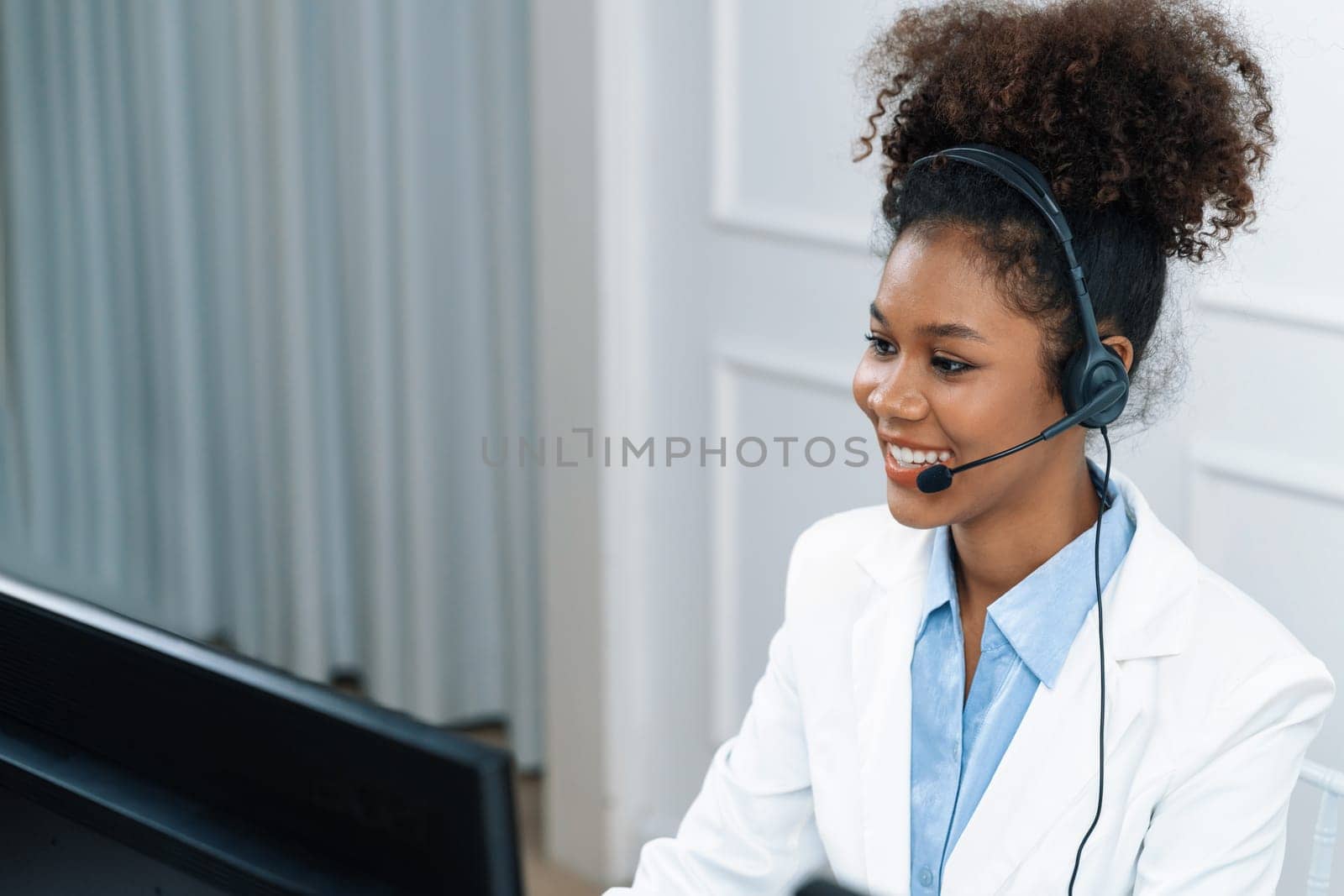 African American young businesswoman wearing headset working in office to support remote crucial customer or colleague. Call center, telemarketing, customer support agent provide service on video call