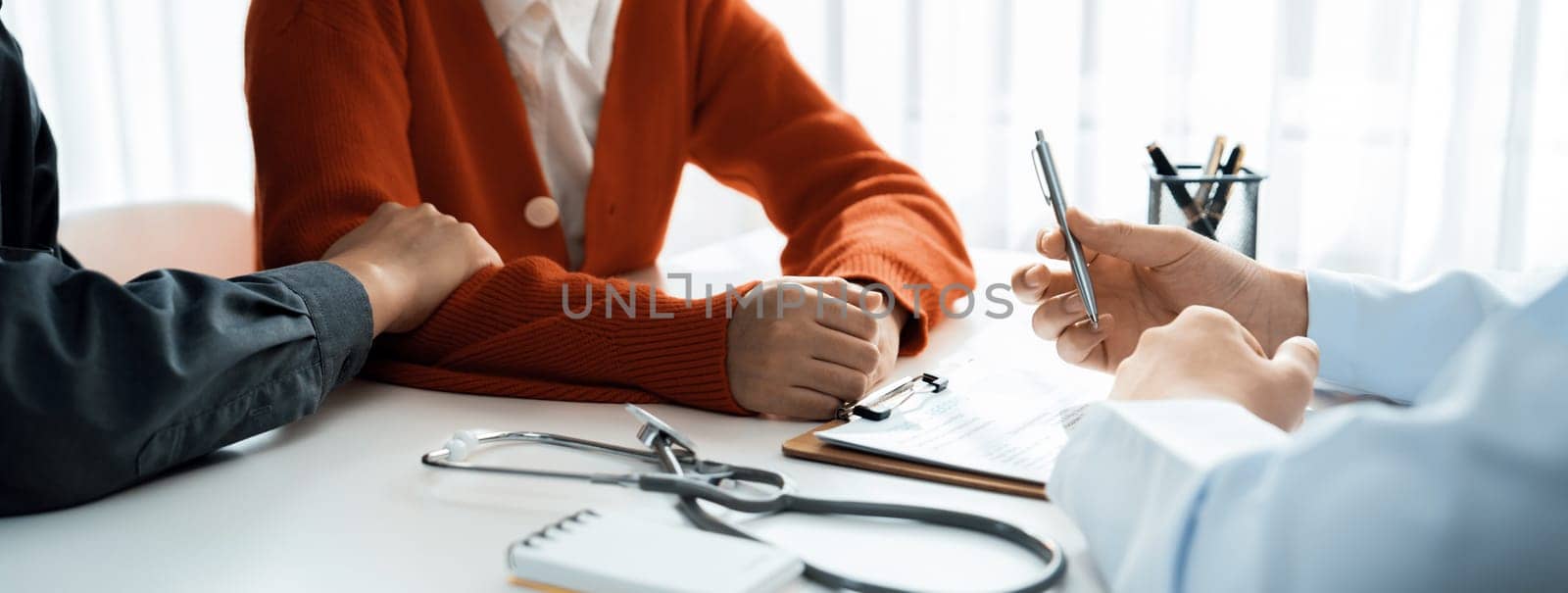 Couple attend fertility or medical consultation with gynecologist at hospital as family planning care for pregnancy. Husband and wife consoling each other through doctor appointment. Panorama Rigid