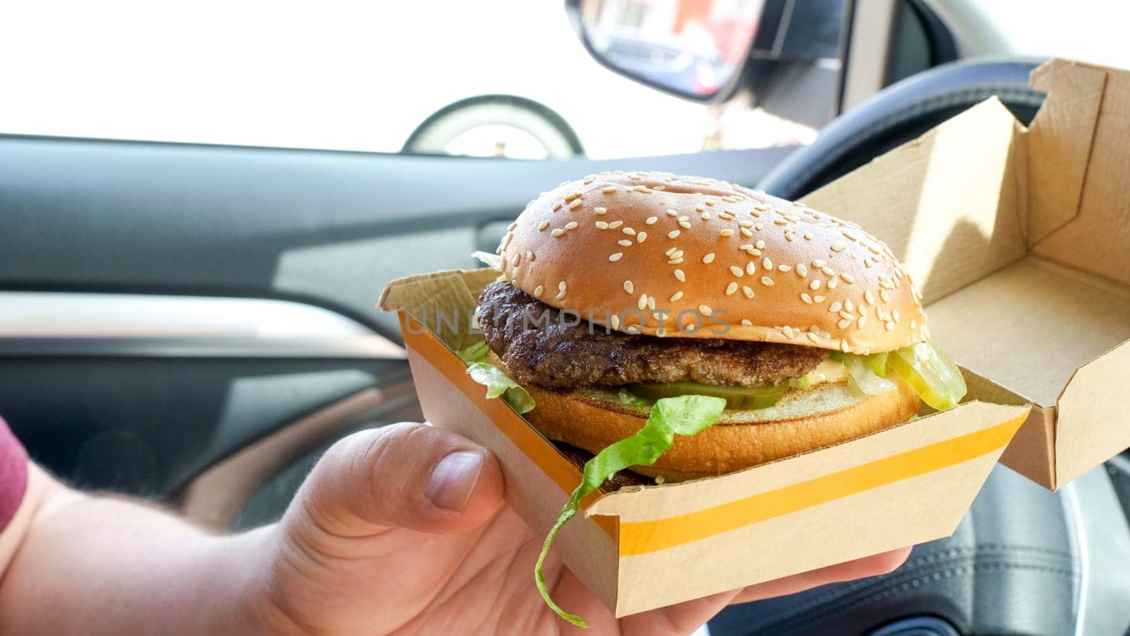 Man is eating Big Mac at McDonald's restaurant. Man ordered Burger in McDonald's restaurant for take out. Ottawa Canada 08.15.2023 by JuliaDorian