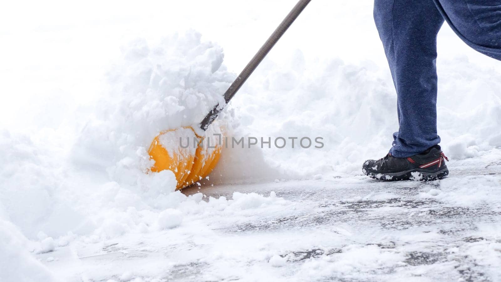 Man shoveling snow off of his driveway after a winter storm in Canada. Man with snow shovel cleans sidewalks in winter. Winter time