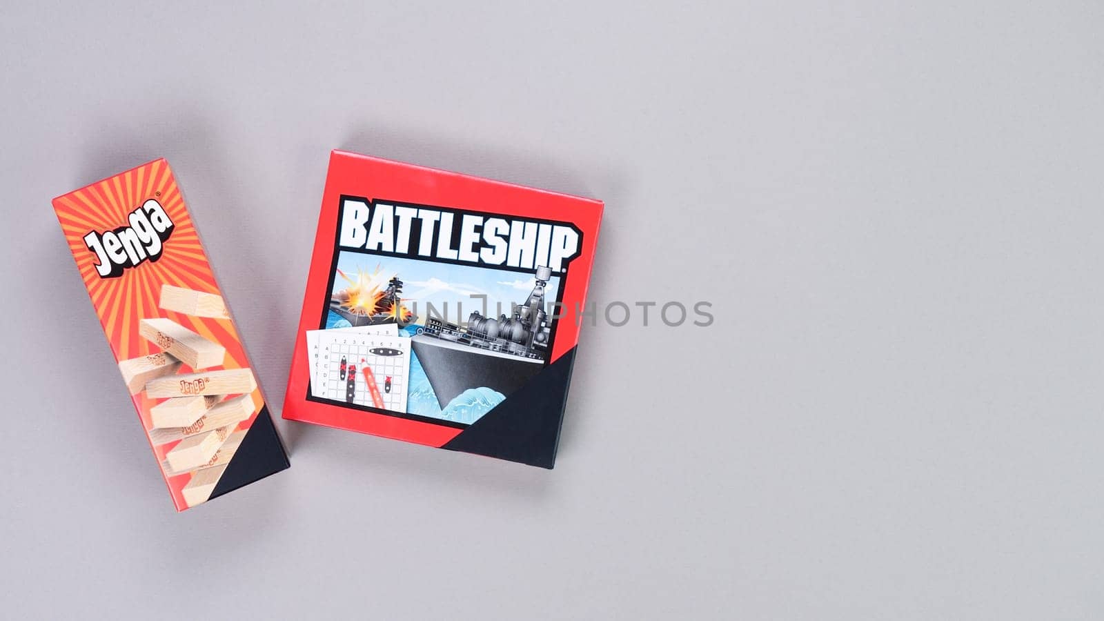 Mini board games on grey background. Fun games to play with kids. Boxes of Jenga, Battleship games. Gatineau, QC Canada - 12-23-2022. by JuliaDorian