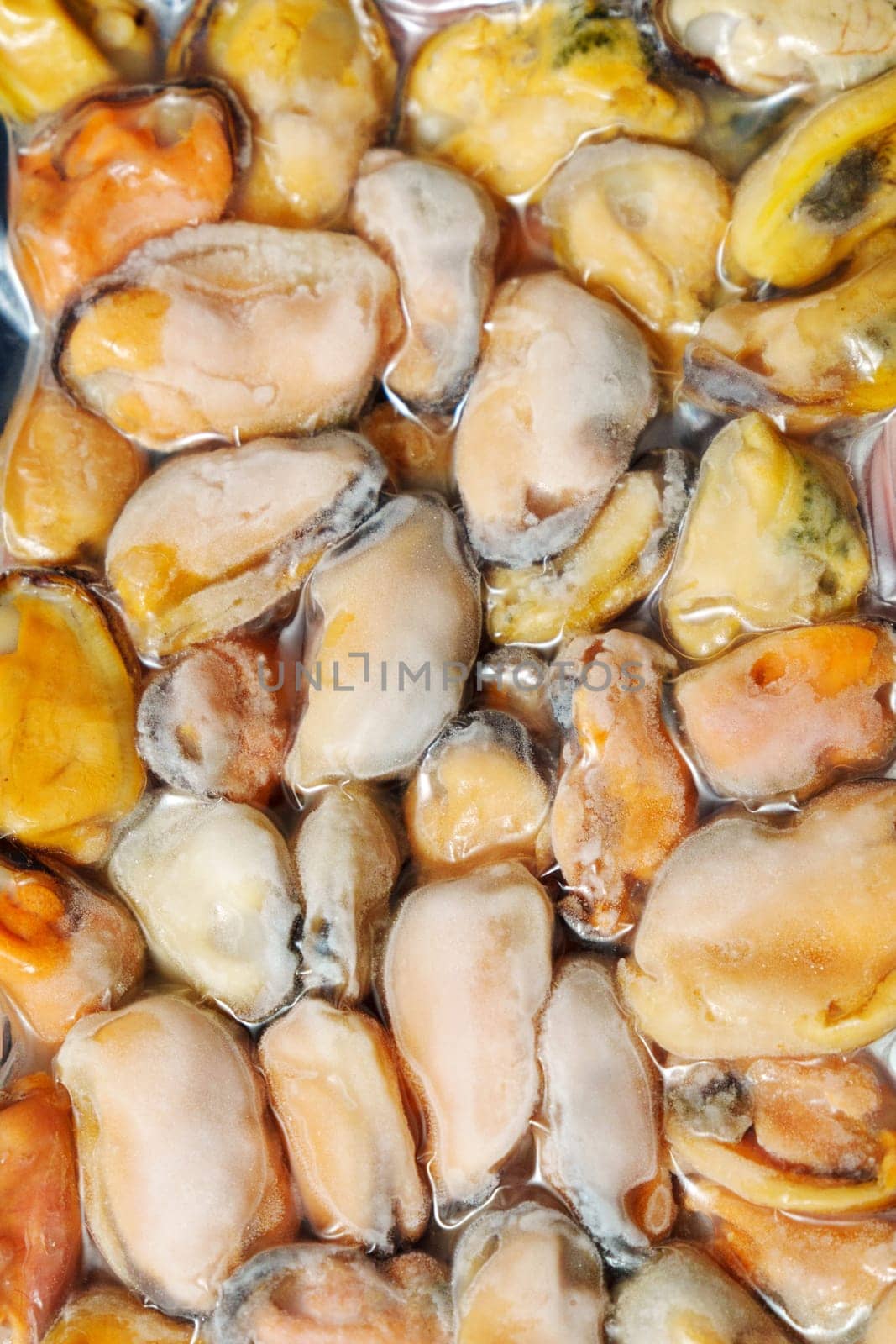 Frozen mussels background. Frozen seafood. Wholesale of fish. Peeled mussels. Vertical photo