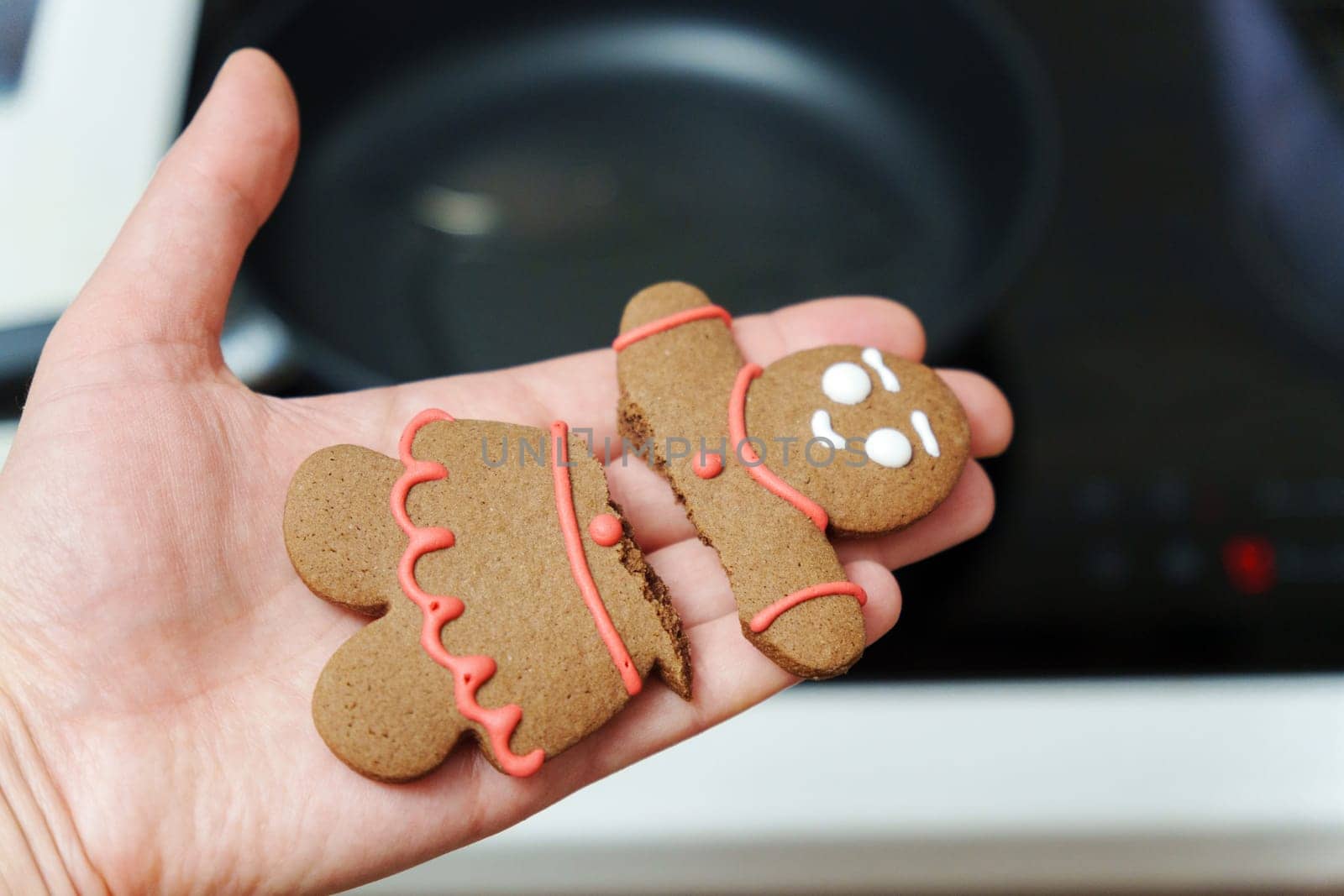 Holding a broken gingerbread man. Close-up, selective focus, Christmas