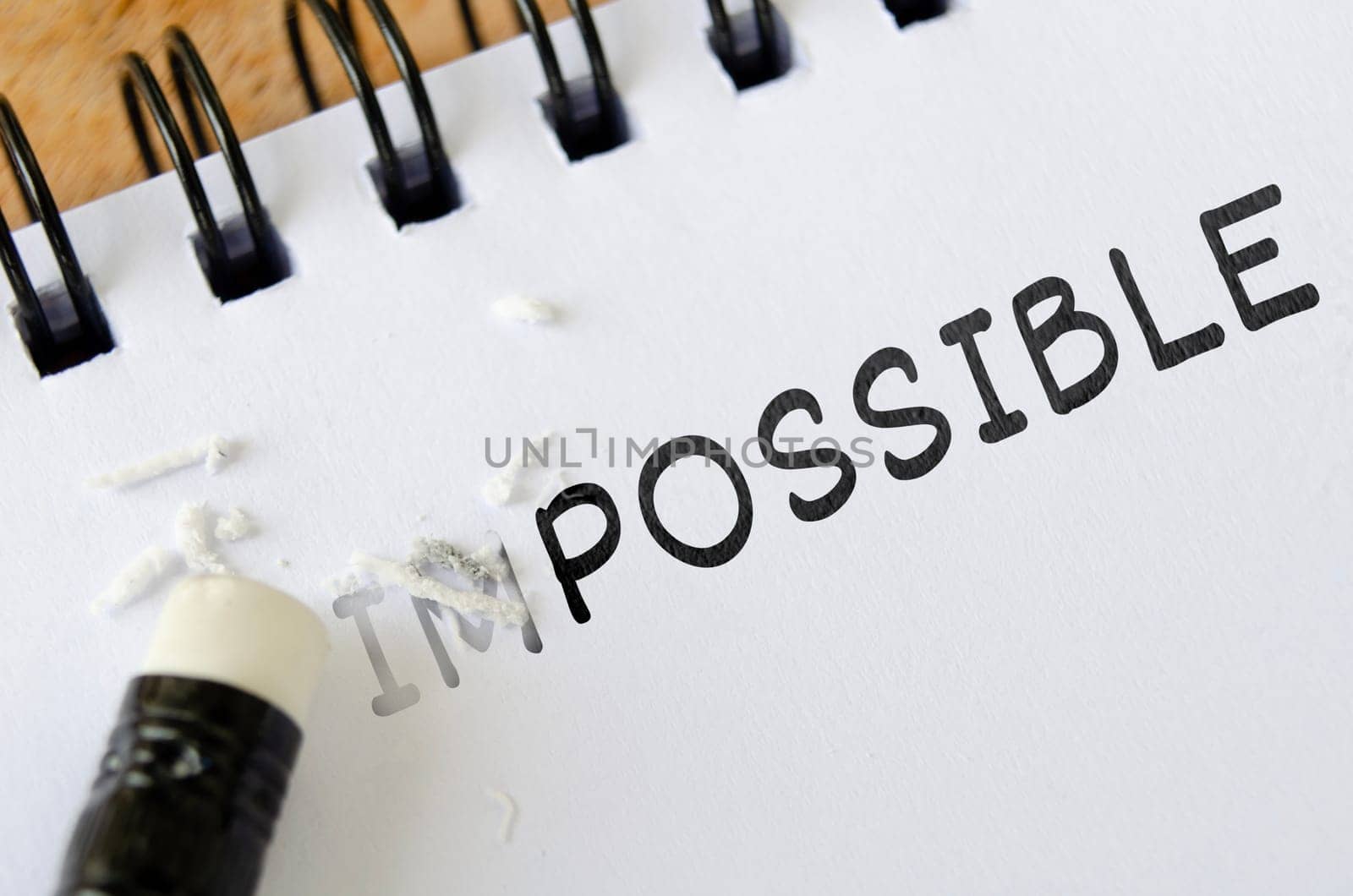 Pencil eraser erasing impossible into possible. Motivational and inspirational concept.