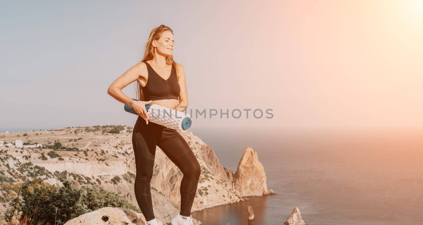 Fitness woman sea. Outdoor workout on yoga mat in park near to ocean beach. Female fitness pilates yoga routine concept. Healthy lifestyle. Happy fit woman exercising with rubber band in park.