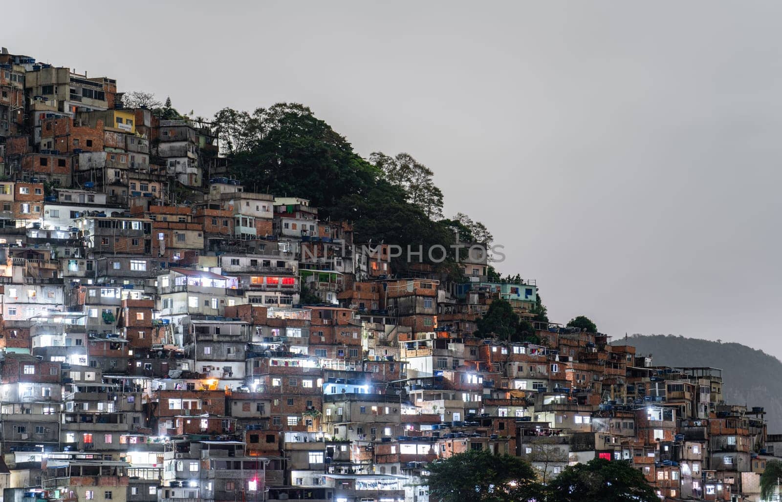 Densely packed hillside favela illuminated at night.