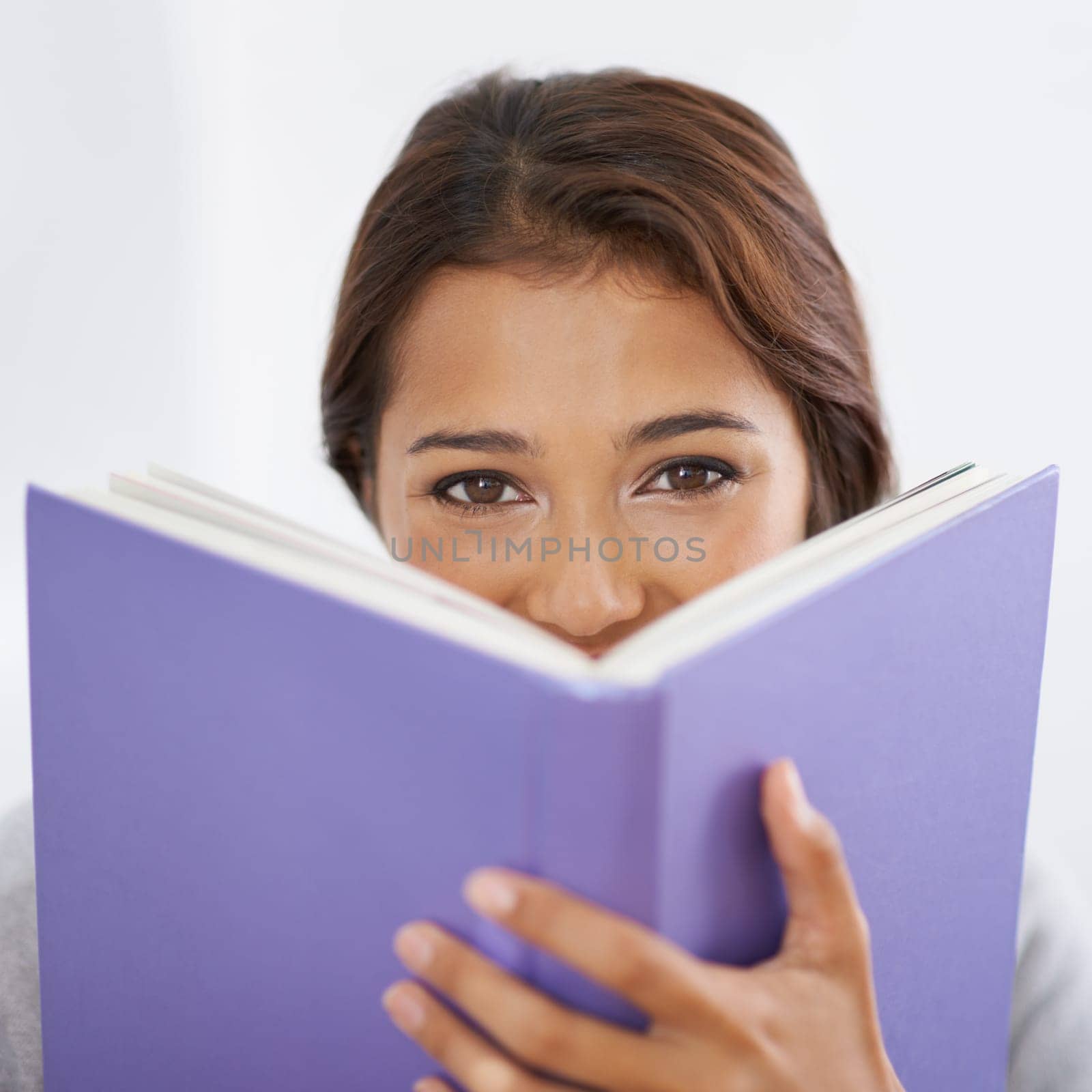 Closeup, student or portrait with book in studio, reading or happy for research of assignment. Young person, eyes or face in notebook for test, studies or positive for education by white background.