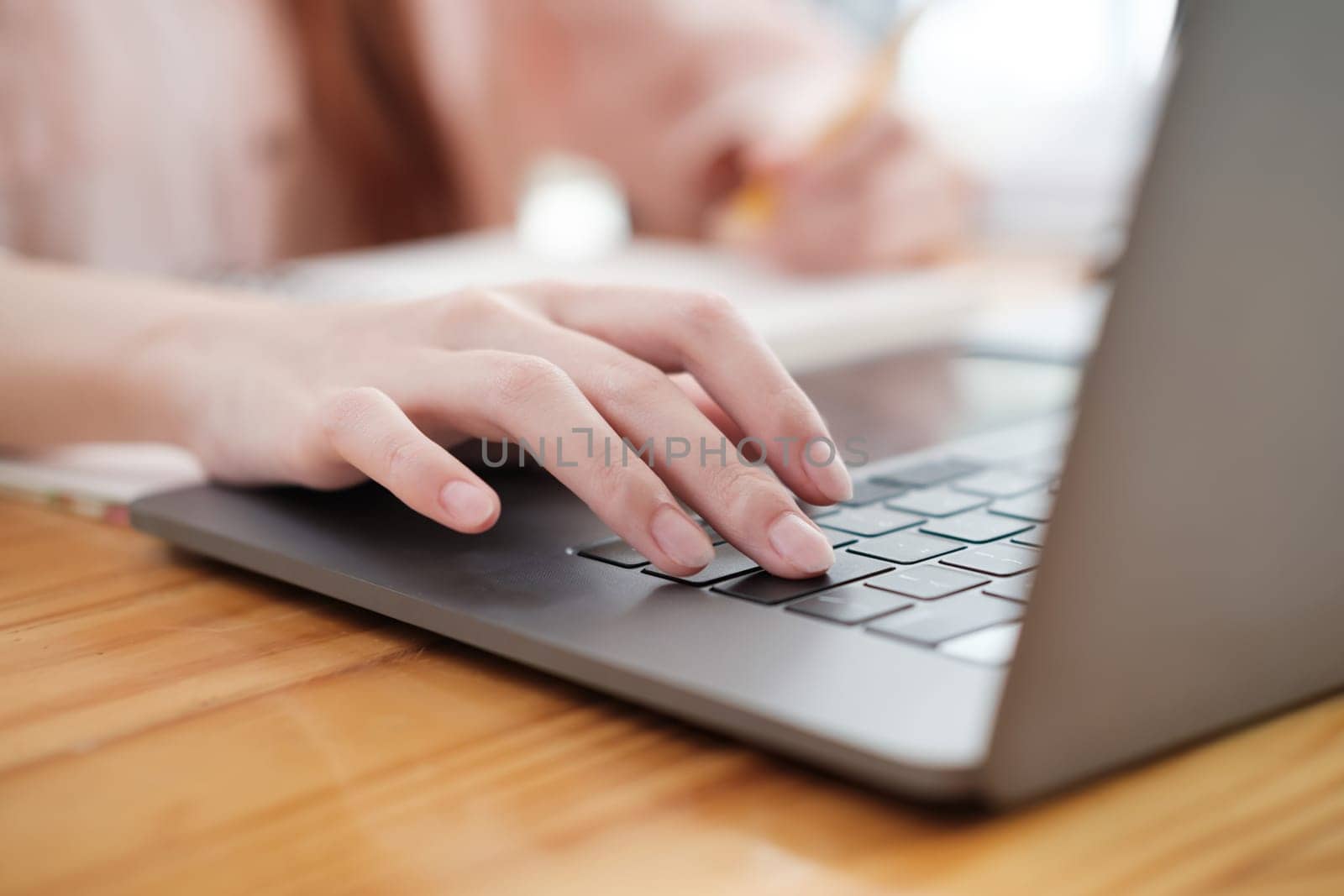 Detailed view of female hands typing on a modern laptop, capturing the essence of digital workflow.