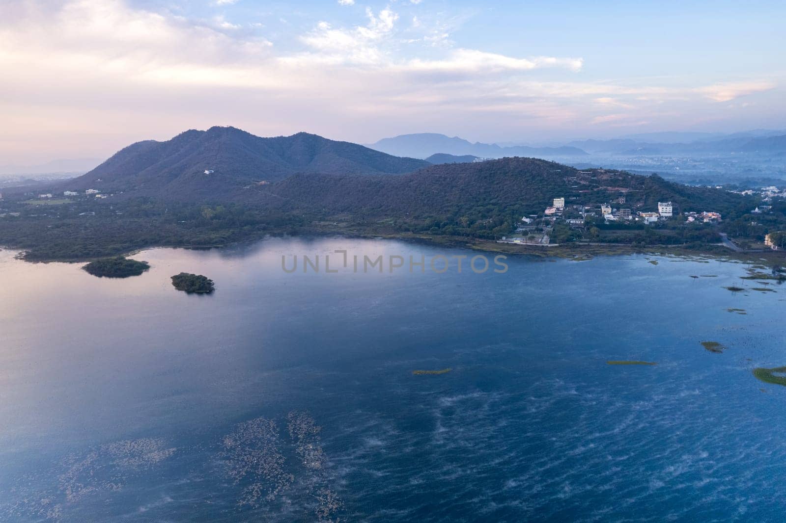 Aerial drone shot showing sunrise dawn dusk over aravalli hills lake pichola fateh sagar and cityscape in Udaipur, Chandigarh, Nainital showing famous tourist spot by Shalinimathur