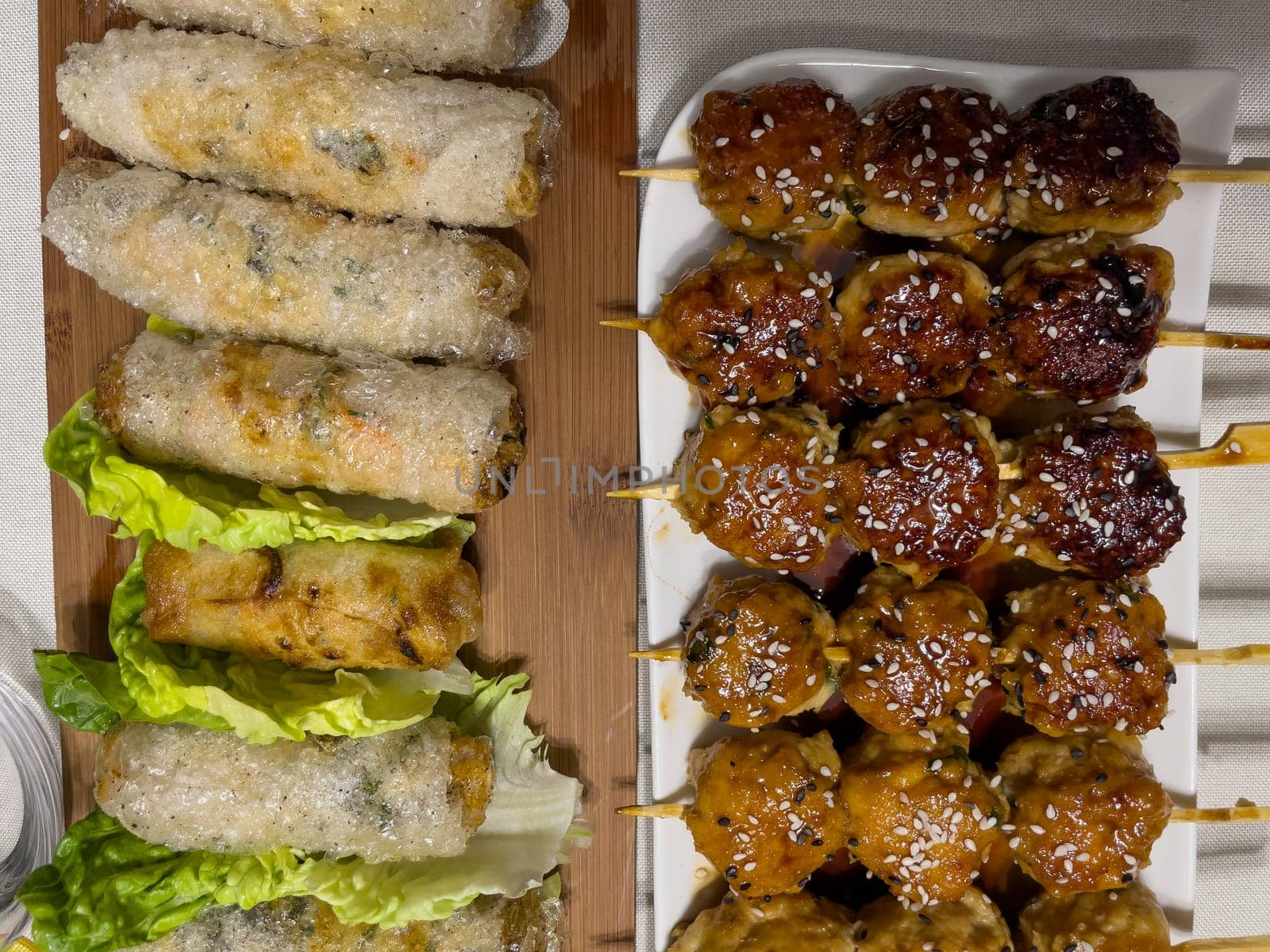 Asian nem dish on a bed of salad and Fried beef meatballs skewers, High quality photo