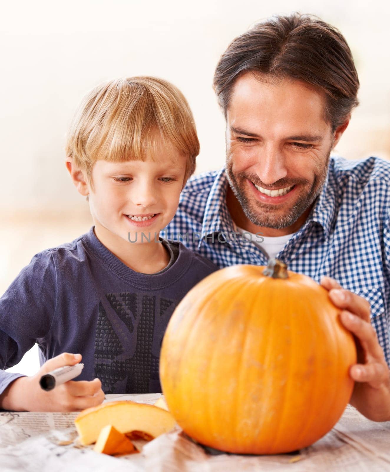 Child, father and smile for drawing on pumpkin, craft and celebrate halloween party at home. Happy boy kid, dad and family writing with pen marker on vegetable, holiday lantern or creative decoration by YuriArcurs