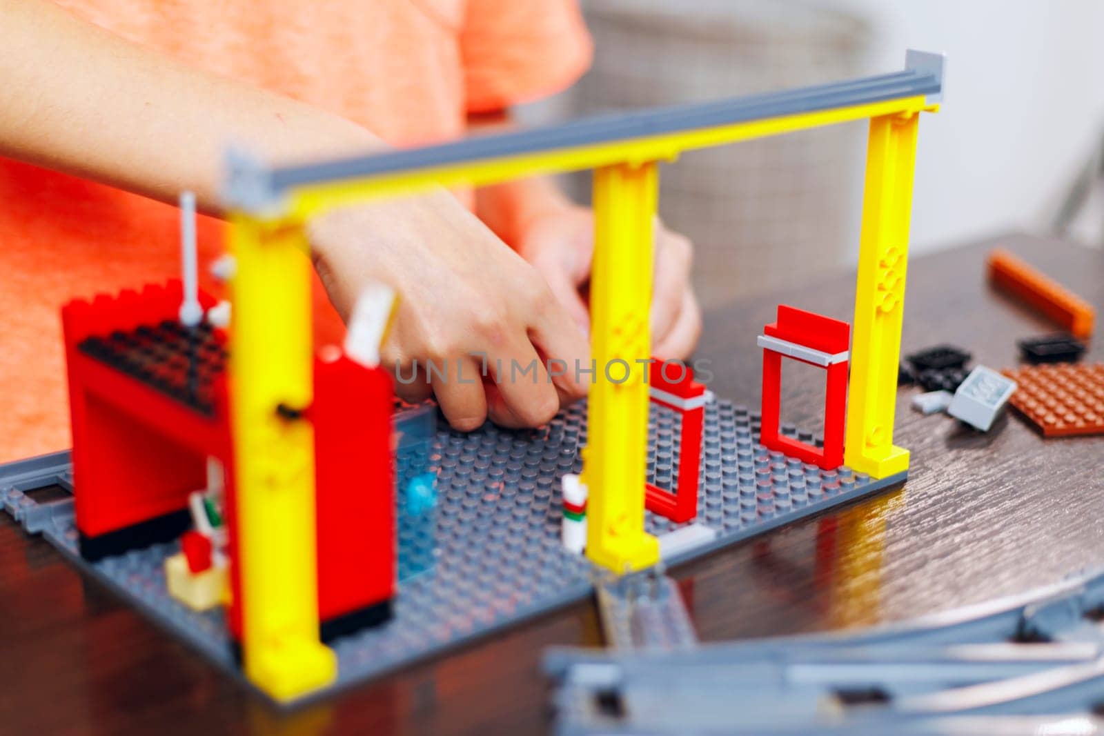 Close-up of a child's hands assembling a toy construction set with colorful pieces, focusing on creative play and development.