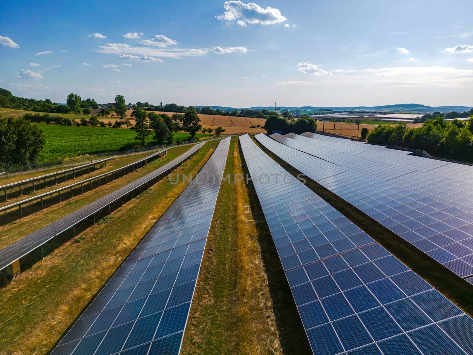 Solar panels in rows on a solar farm in the countryside in sunshine in autumn