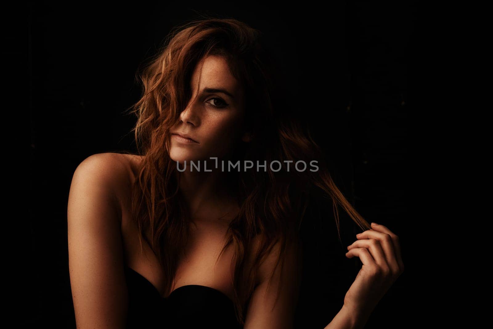 Woman, hair care and ginger with portrait, serious and shampoo treatment in a studio. Relax, beauty and female person with wavy texture and fresh haircut with balayage coloring with black background by YuriArcurs