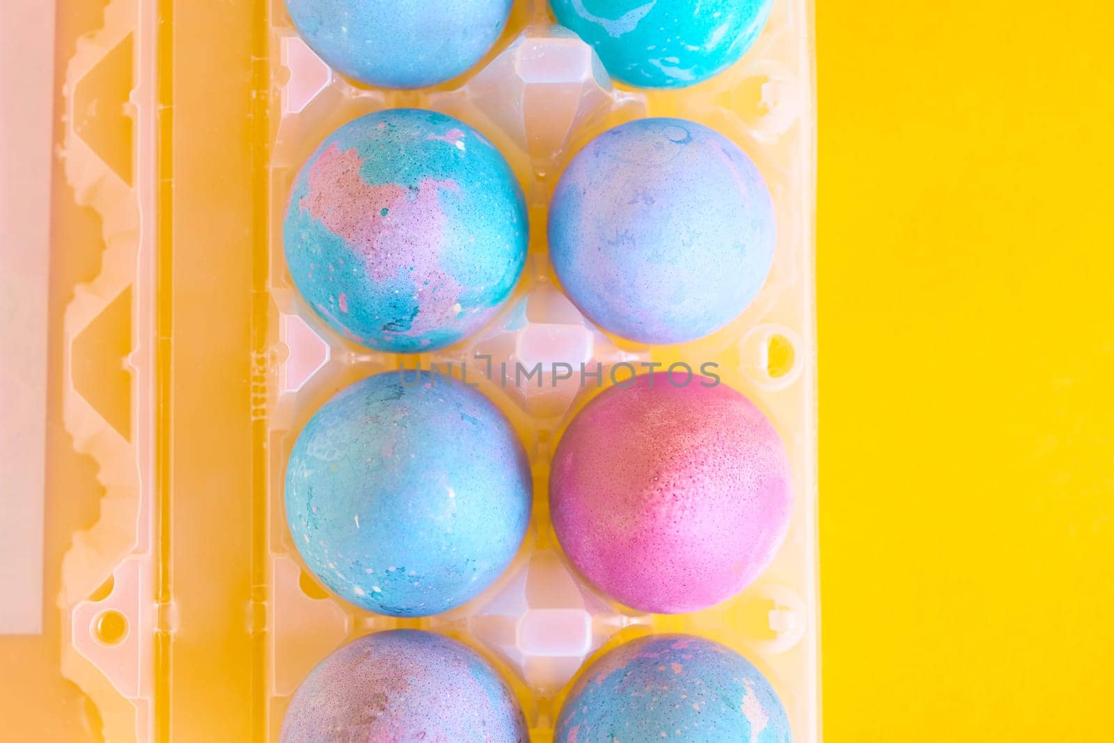 Painted Easter eggs with space intergalactic pattern in stand on yellow background