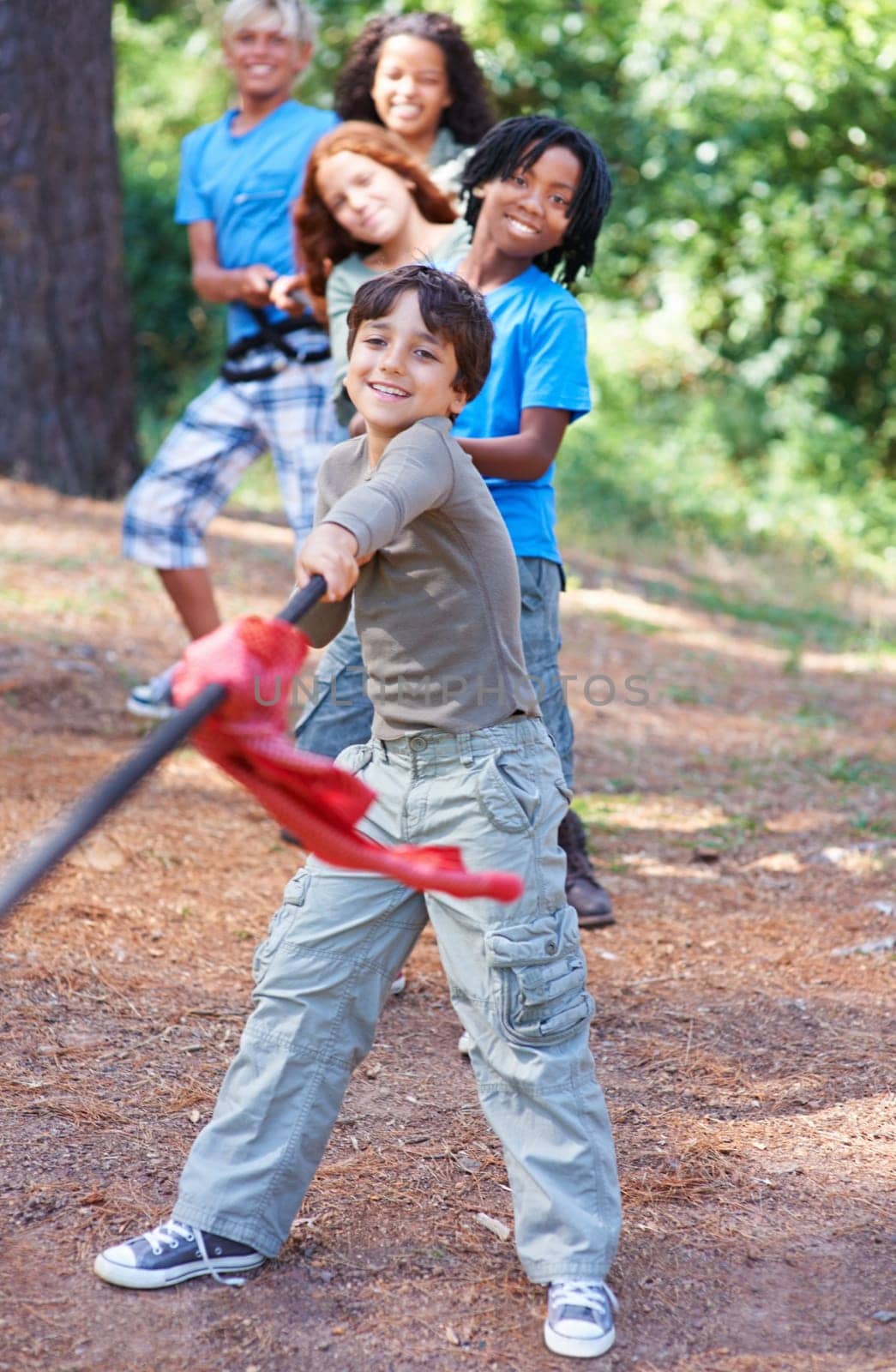 Children, forest and tug of war for play adventure, challenge and strength game in woods with summer camping. Kids, diversity or competitive in outdoor environment for fresh air or happiness by trees.