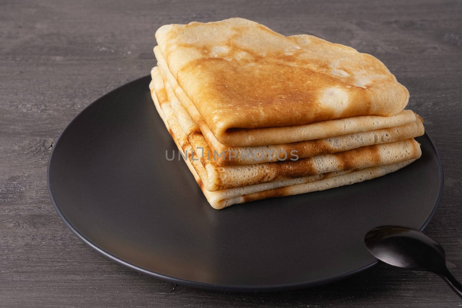 Thin pancakes on the grey background.