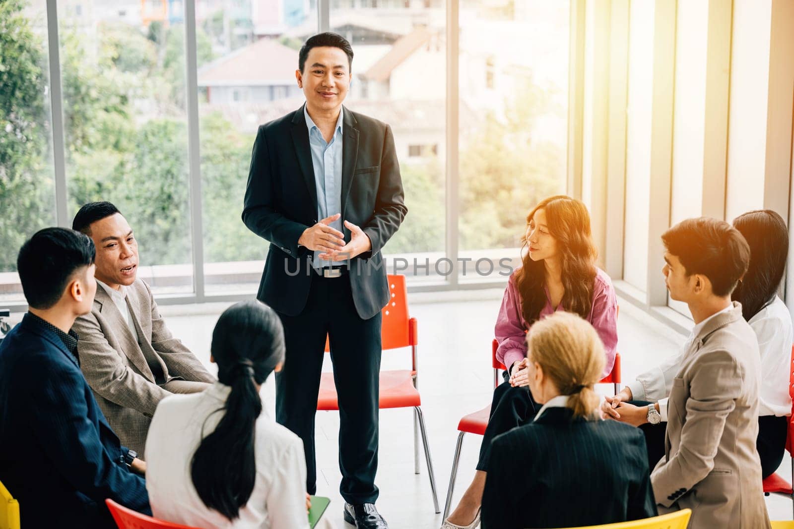 In a modern office, a diverse group of businesspeople plans, discusses, and presents in a business meeting seminar room. Their teamwork, diversity, and confidence drive success. by Sorapop