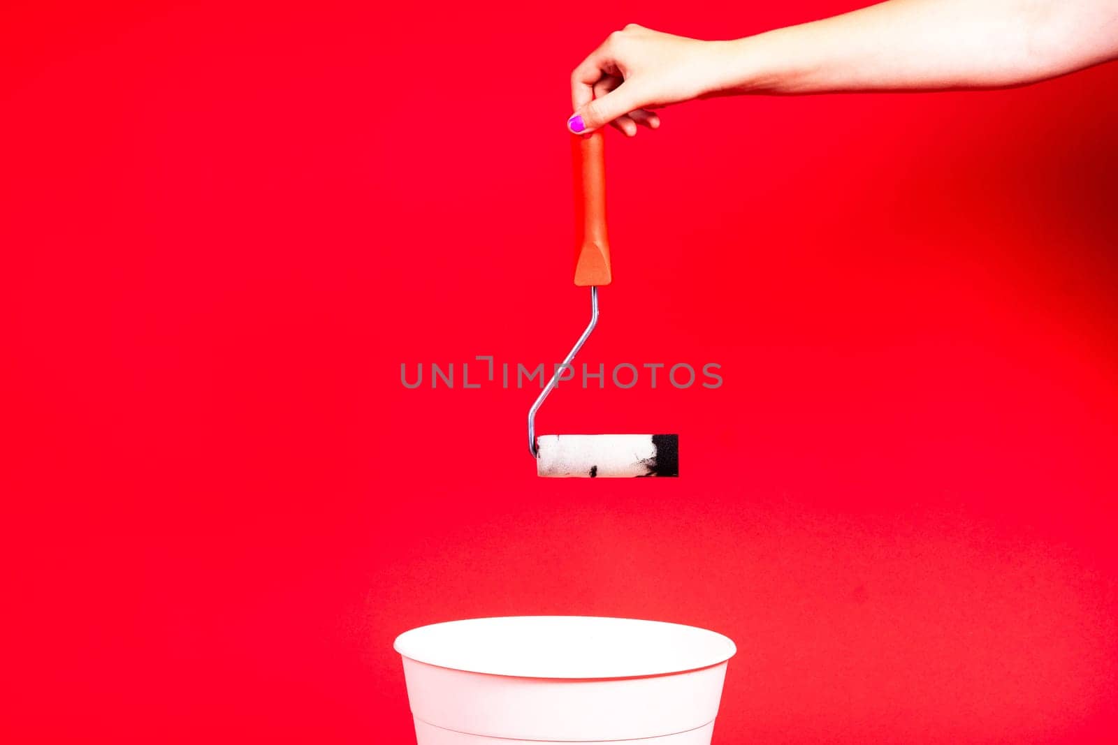 Construction roller is thrown into the trash on red background
