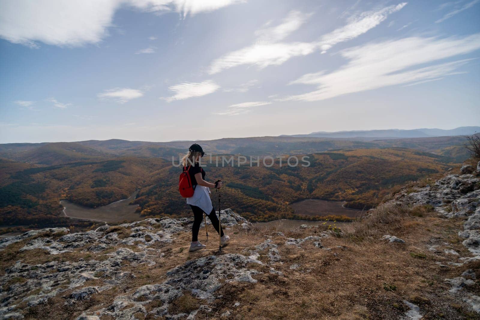 woman on mountain peak looking in beautiful mountain valley in autumn. Landscape with sporty young woman, blu sky in fall. Hiking. Nature by Matiunina