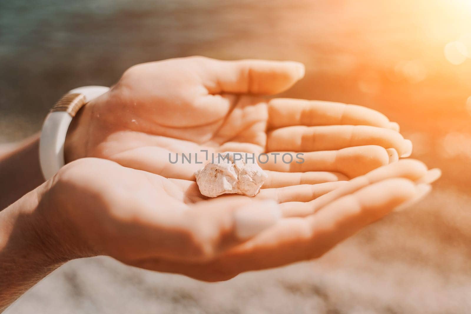 Beach vacation snapshot: A woman in a swimsuit holding a pebble in her hands, enjoying the serenity of the beach and the beauty of nature, creating a peaceful and relaxing atmosphere