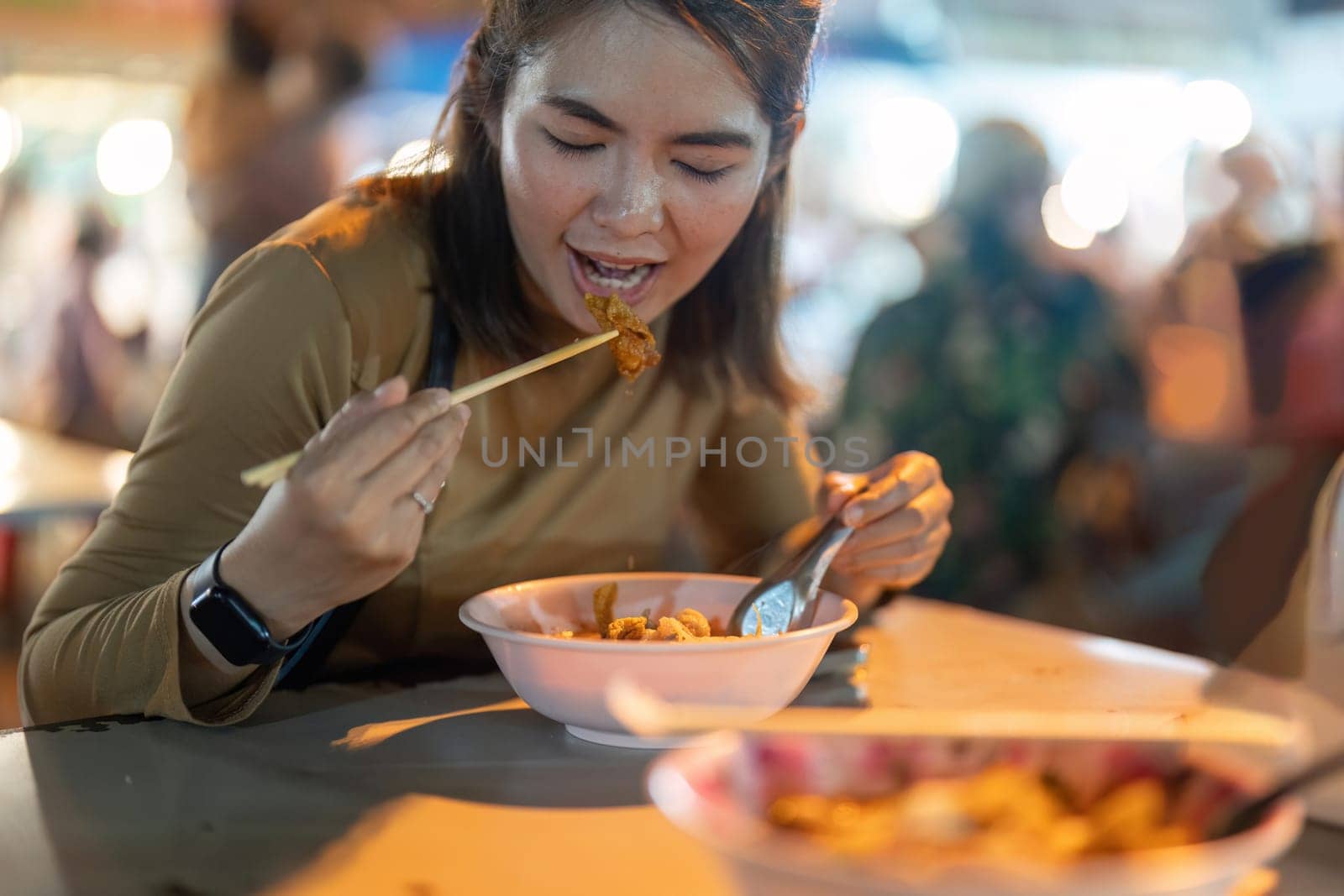 Traveler Asian woman enjoy eating noodle at night market. traditional Chiang Mai Thailand street food..