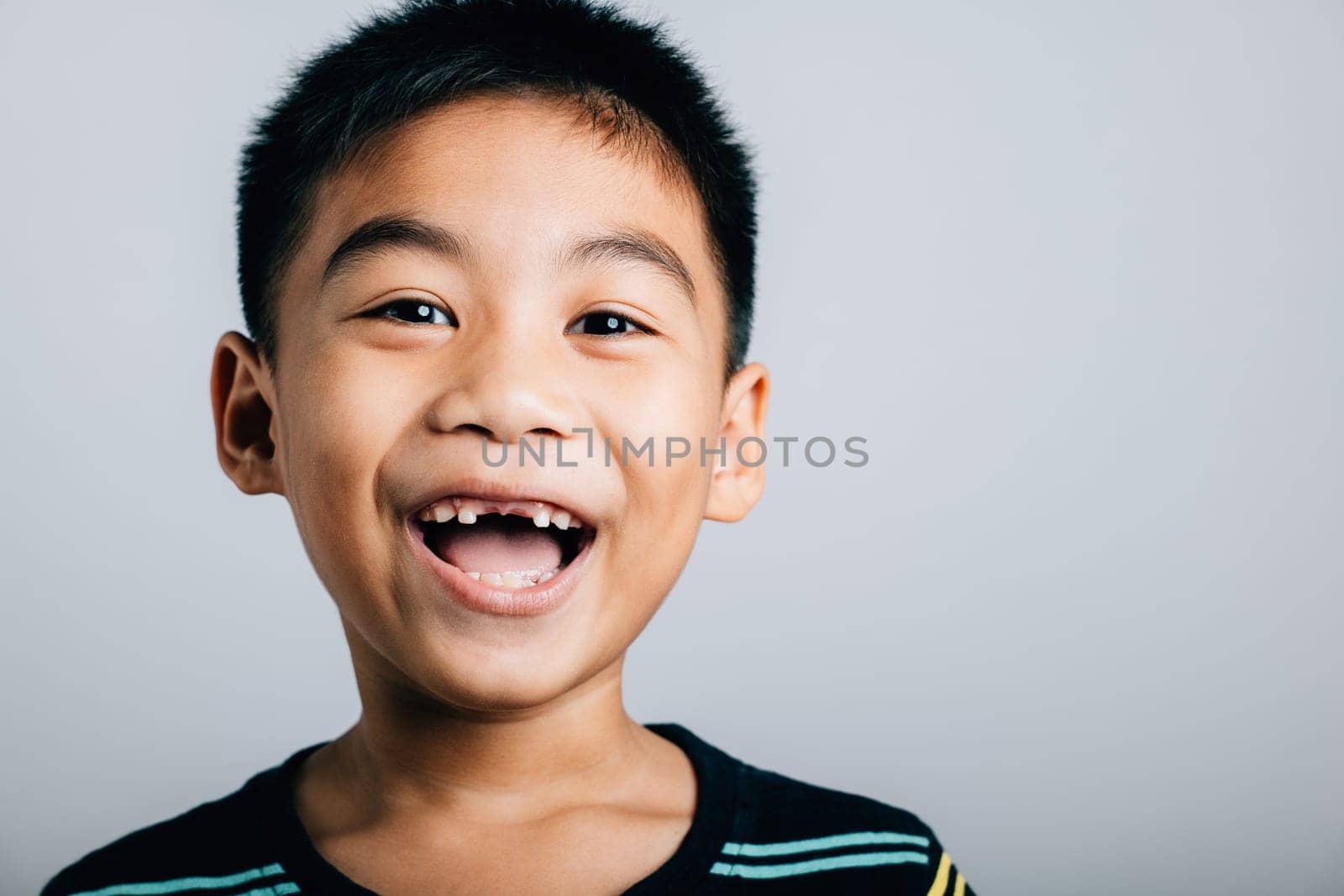 Boy smiling wide showing gap from lost upper tooth. Child dental development isolated on white. Joyful tooth loss growth change. Children show teeth new gap, dentist problems by Sorapop