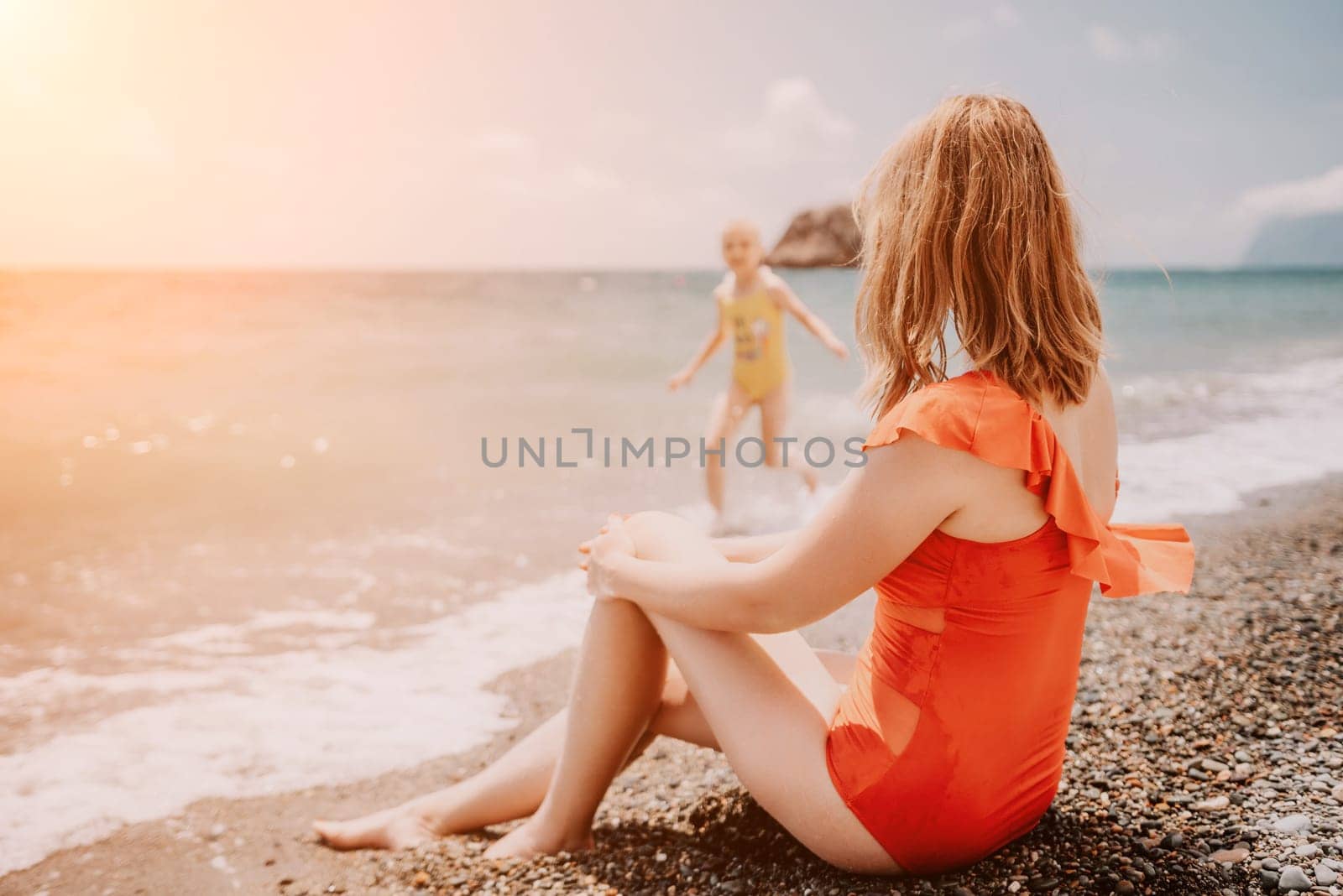 Happy loving family mother and daughter having fun together on the beach. Mum playing with her kid in holiday vacation next to the ocean - Family lifestyle and love concept.