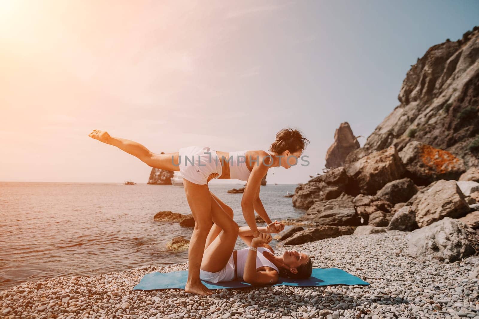 Woman sea yoga. Back view of free calm happy satisfied woman with long hair standing on top rock with yoga position against of sky by the sea. Healthy lifestyle outdoors in nature, fitness concept.