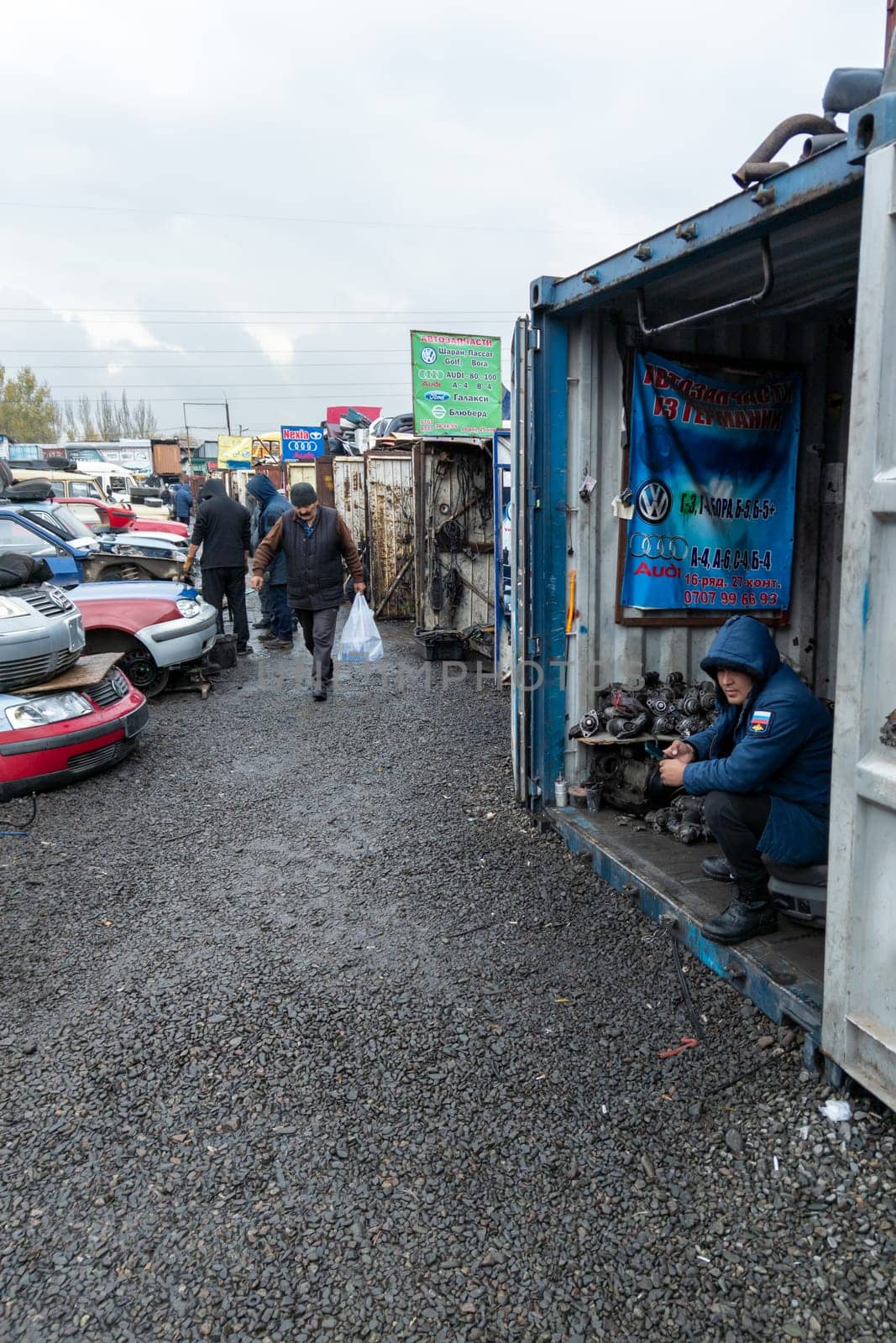 man selling Volkswagen car parts at open air used spare parts market in Kudaybergen, Bishkek, Kyrgyzstan by z1b