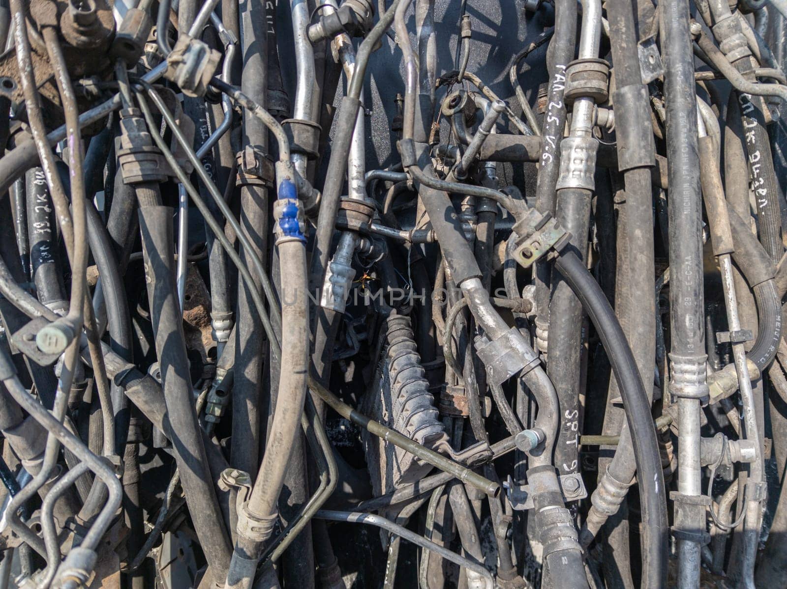 used car tubes and electrical wires hanging on the wall at junkyard market Kudaybergen, Bishkek, Kyrgyzstan - November 11, 2022