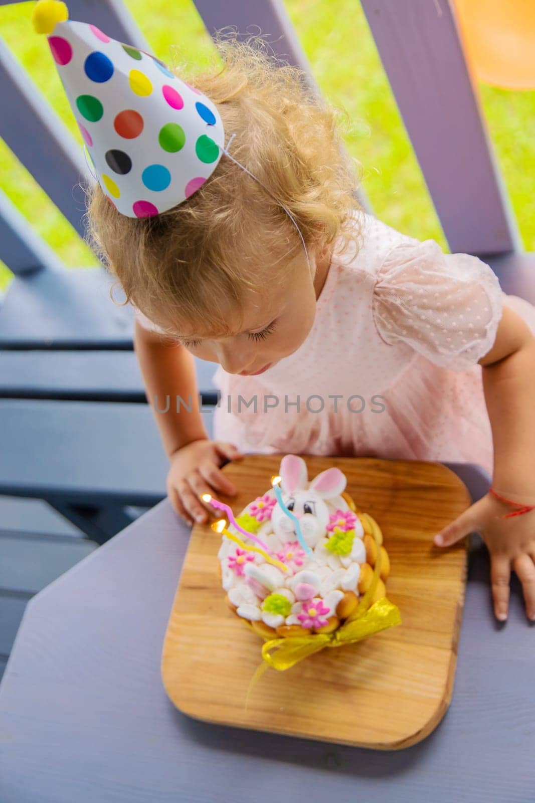 A three year old child blows candles on a cake. Selective focus. Kid.