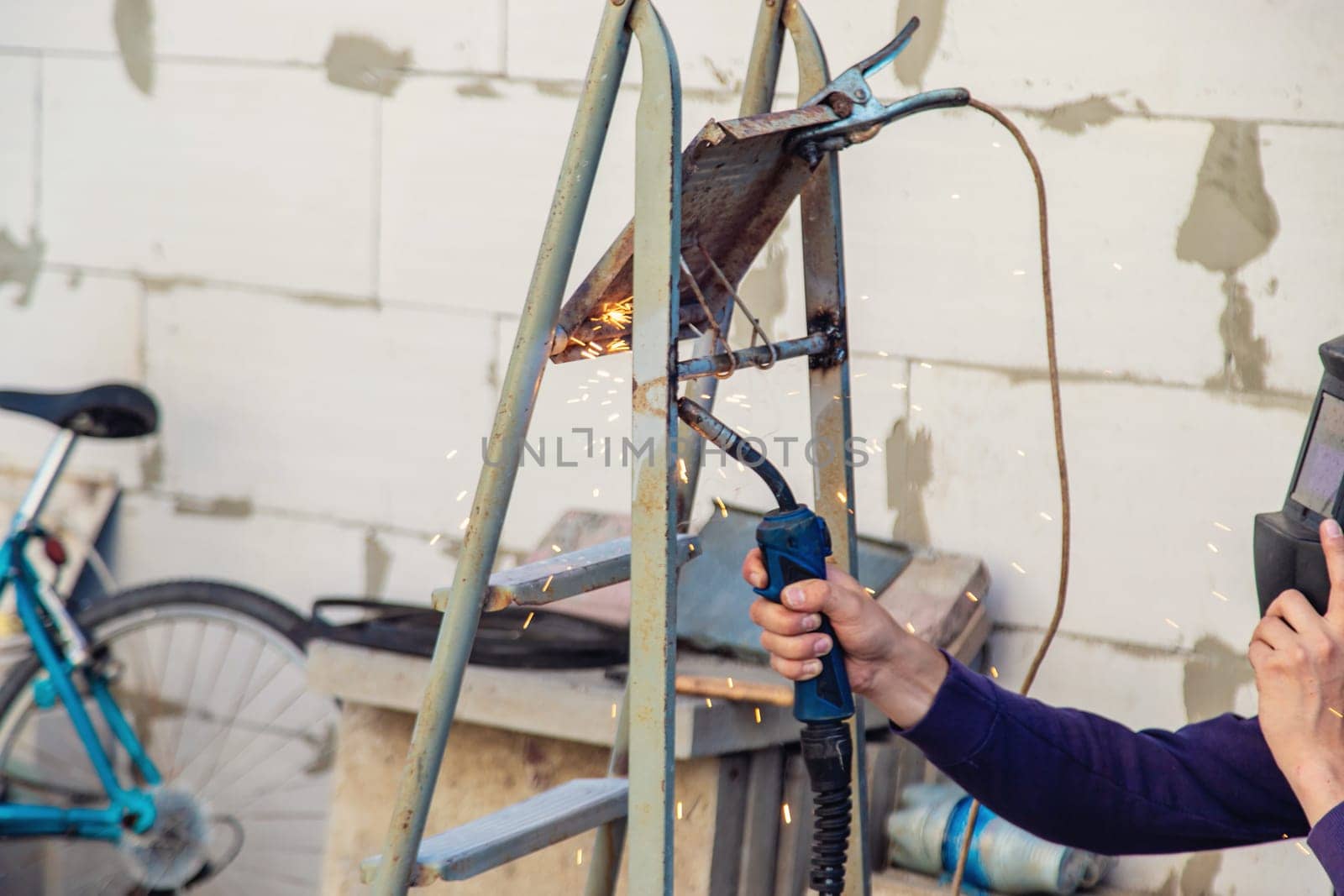 A master welds metal. Selective focus. Hand.