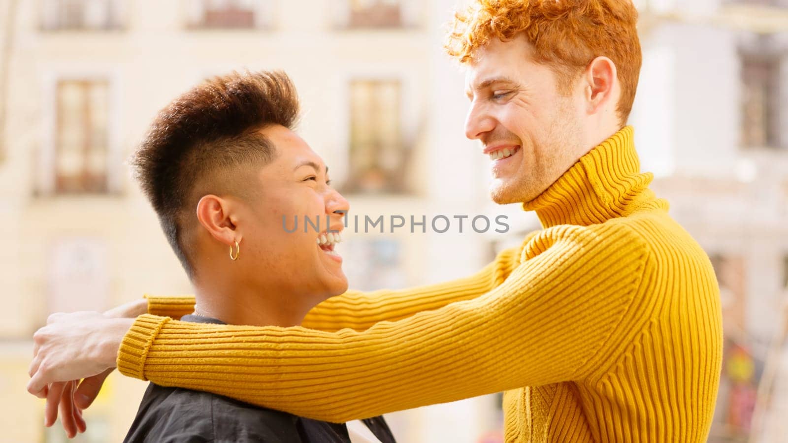 Romantic gay couple embracing together at the balcony at home