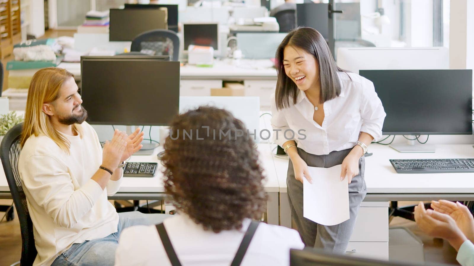 Colleagues applaud a businesswoman after a presentation in a meeting by ivanmoreno